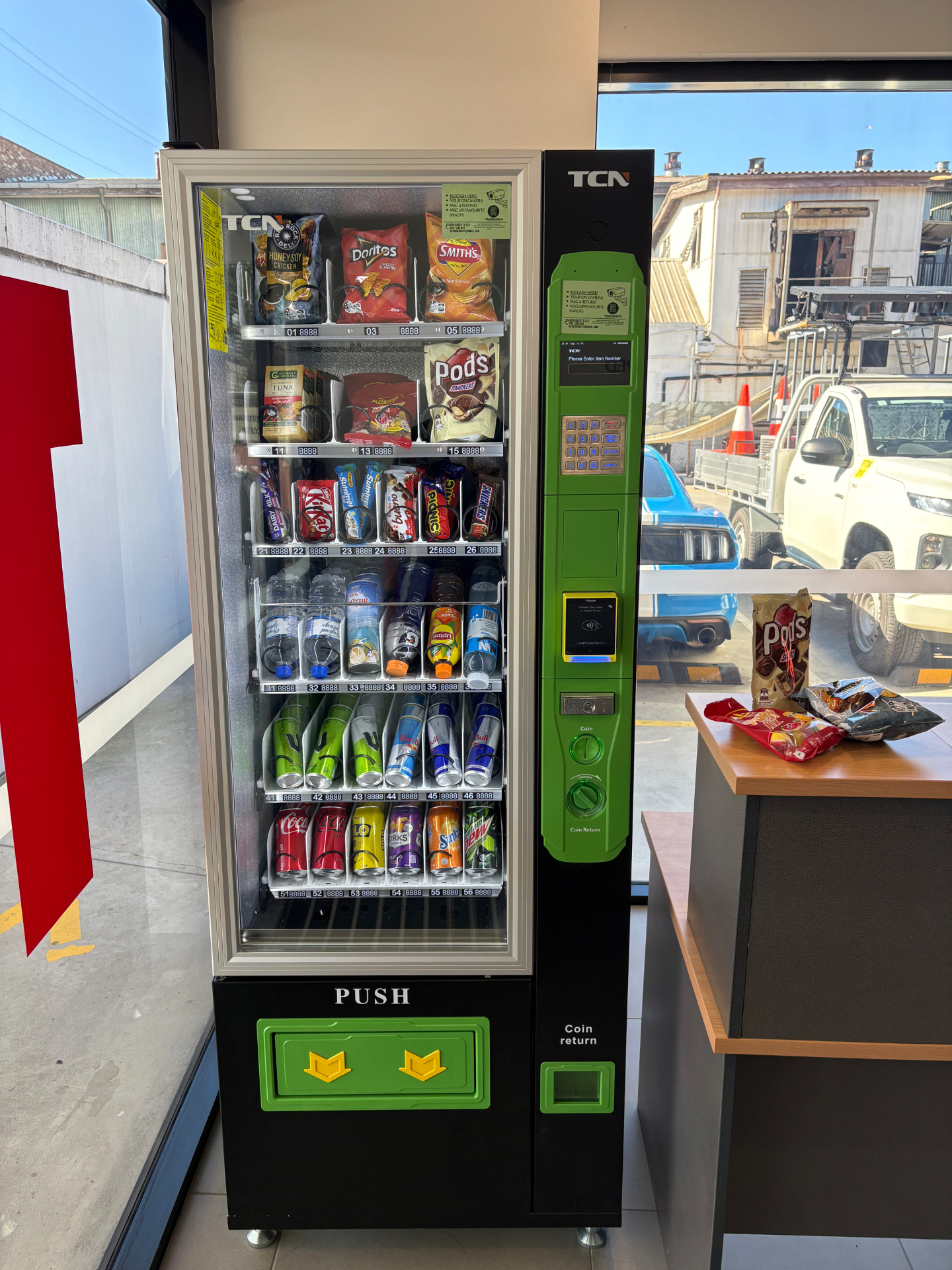 Vendor Bros. office vending machine stocked with chips, chocolate, water and energy drinks